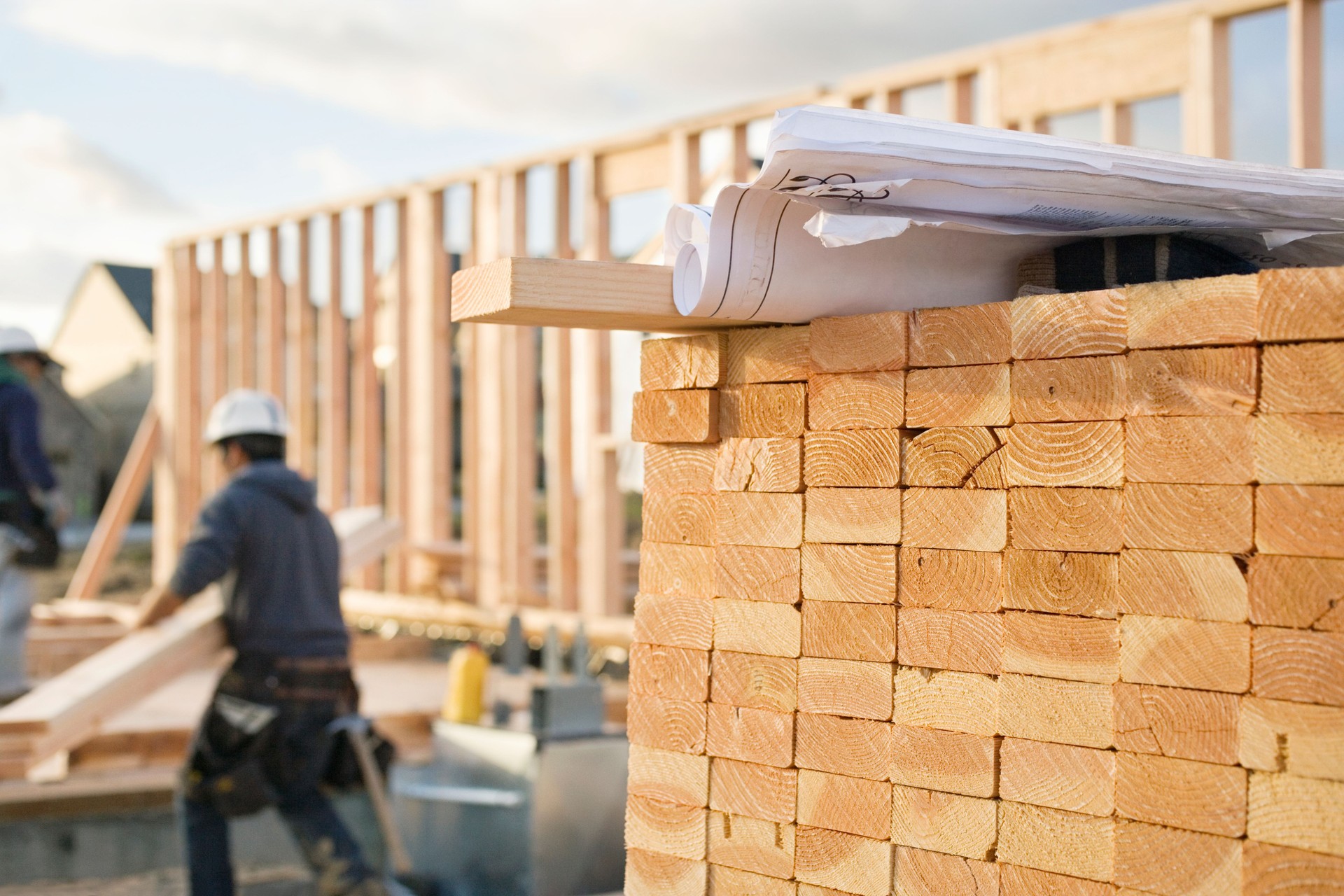 Stacked Lumber and Blueprints at a Construction Site